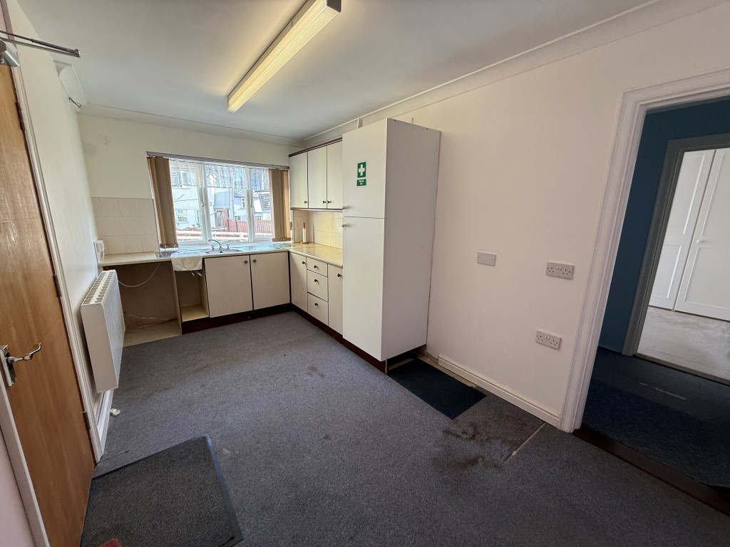 Lot: 6 - INVESTMENT OPPORTUNITY IN TOWN CENTRE LOCATION WITH OFF ROAD PARKING - Carpeted kitchen area with cupboards and window
